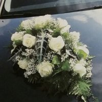 Blumenstrauß mit weißen Blumen auf einem Auto